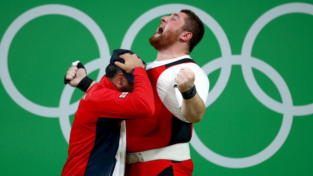 Lasha Talakhadze celebrates with his coach after setting a world record to win the gold medal in the men's over 105-kilogram competition on Tuesday.