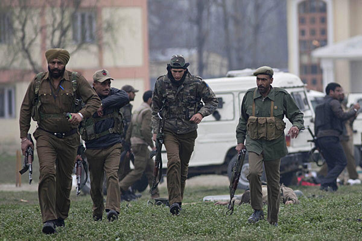 Indian police officers secure the area after a gun battle in Kashmir left five Indian paramilitary officers and two militants dead.