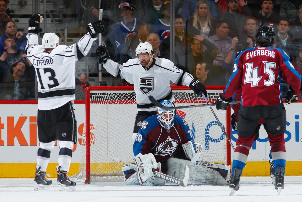 Kyle Clifford (13) celebrates his goal against Colorado goalie Reto Berra with Kings teammate Justin Williams as Dennis Everberg looks on Tuesday night.