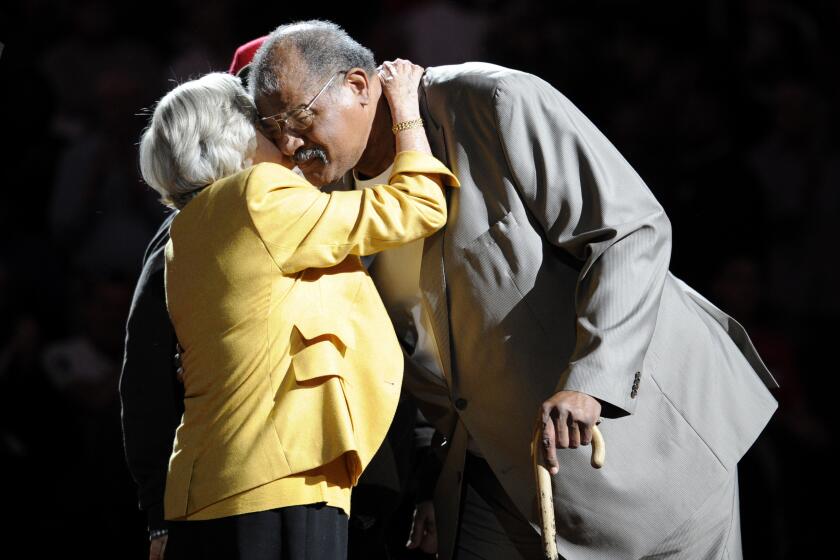 Former Washington Bullets basketball player and Hall of Famer Wes Unseld, right, is greeted by Irene Pollin, left, wife of the late Bullets' owner Abe Pollin, during a ceremony to celebrate the 35th anniversary of the Bullets only NBA championship, during halftime of an NBA basketball game between the Washington Wizards and the Indiana Pacers, Saturday, April 6, 2013, in Washington. The Bullets later changed their name to the Wizards. (AP Photo/Nick Wass)