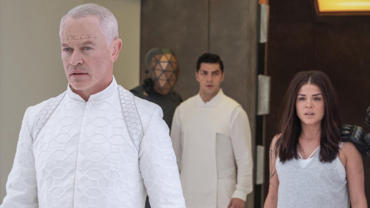 Neal McDonough, left, Jason Diaz and Marie Avgeropoulos in a scene from "The 100" on the CW