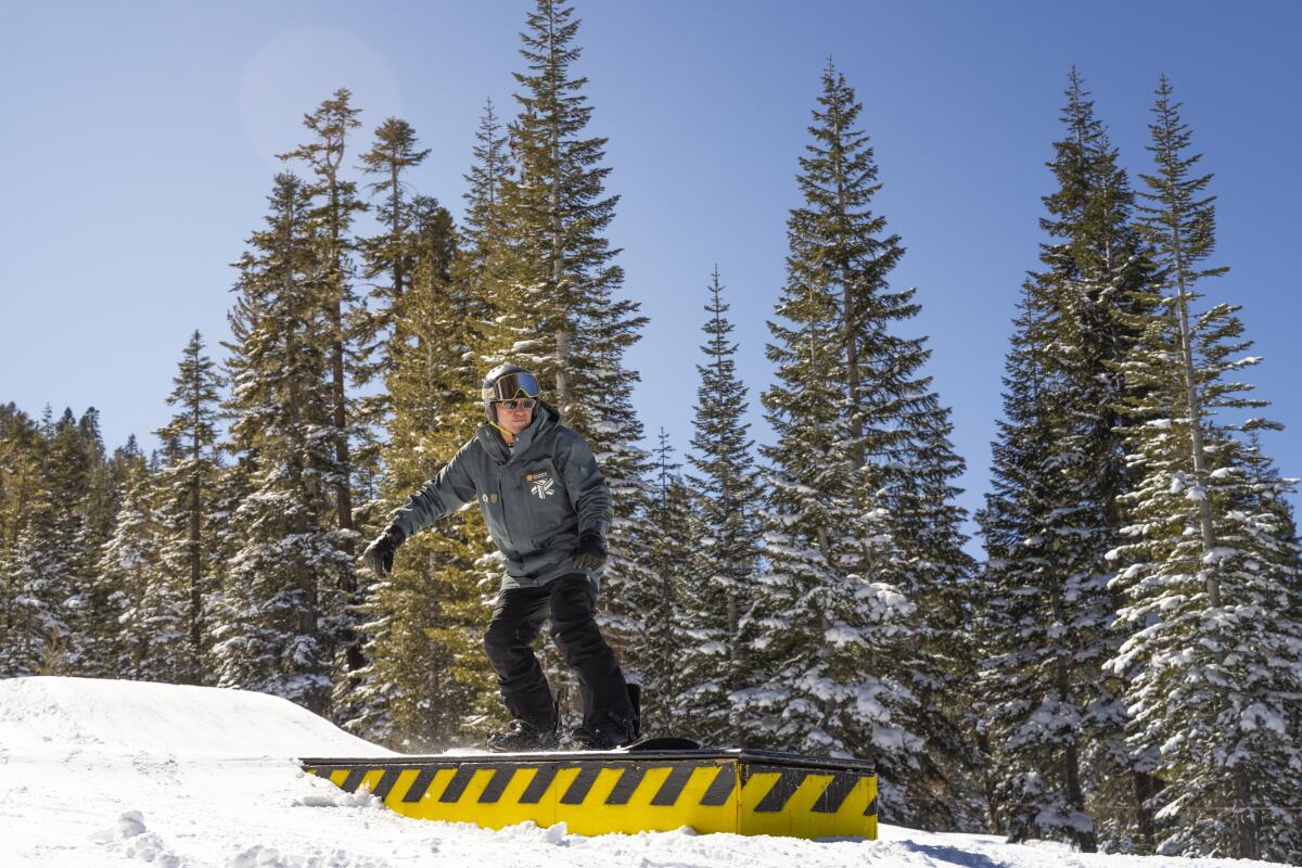 Dick Schulze strikes a pose on a snowboard.