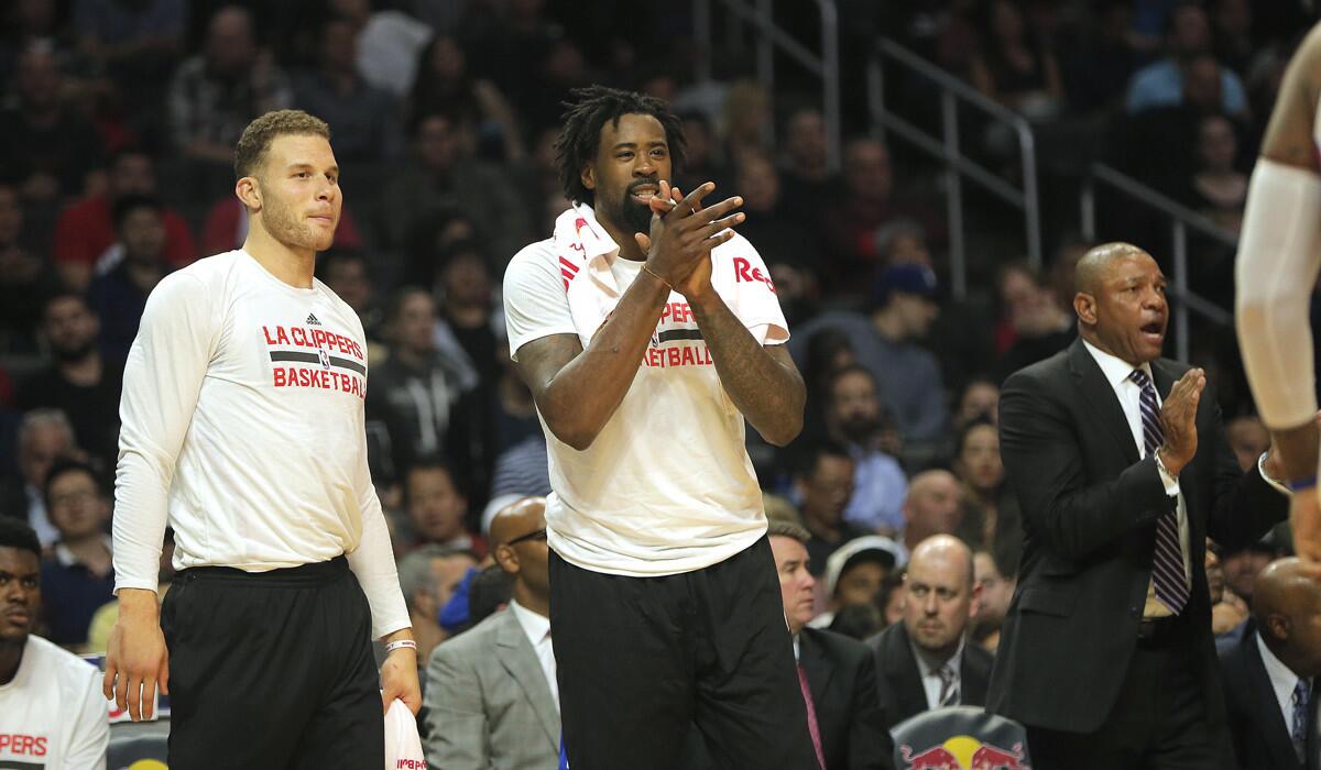 Clippers forward Blake Griffin, left, DeAndre Jordan, center, and Coach Doc Rivers cheer on the team as the Clippers beat the Brooklyn Nets 127-95 at Staples Center on Monday.