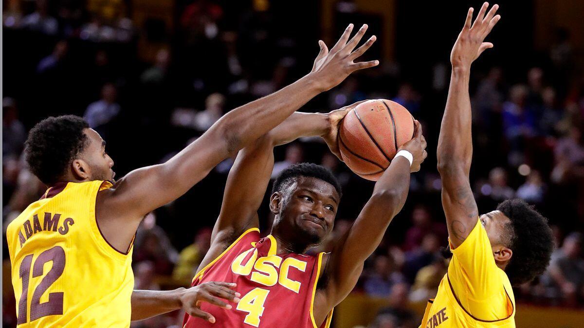 USC forward Chimezie Metu (4) is pressured by Arizona State forward Andre Adams (12) and guard Shannon Evans II during the first half Sunday.