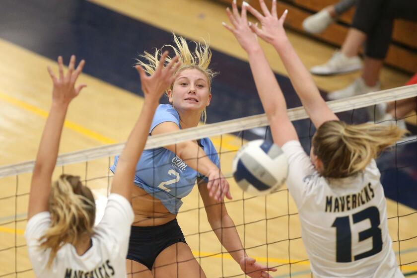 Corona del Mar outside hitter Nikke Senske (2) puts the ball away for a point past La Costa blockers Avry Tatum (13) during quarterfinals of the CIF State Southern California Regional Division I playoffs on Thursday.