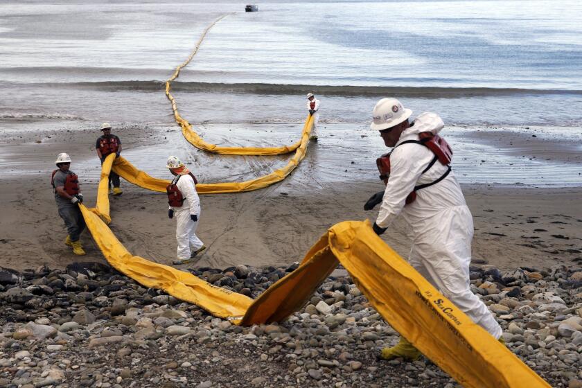 Workers prepare an oil containment boom at Refugio State Beach after last month's oil spill north of Santa Barbara.