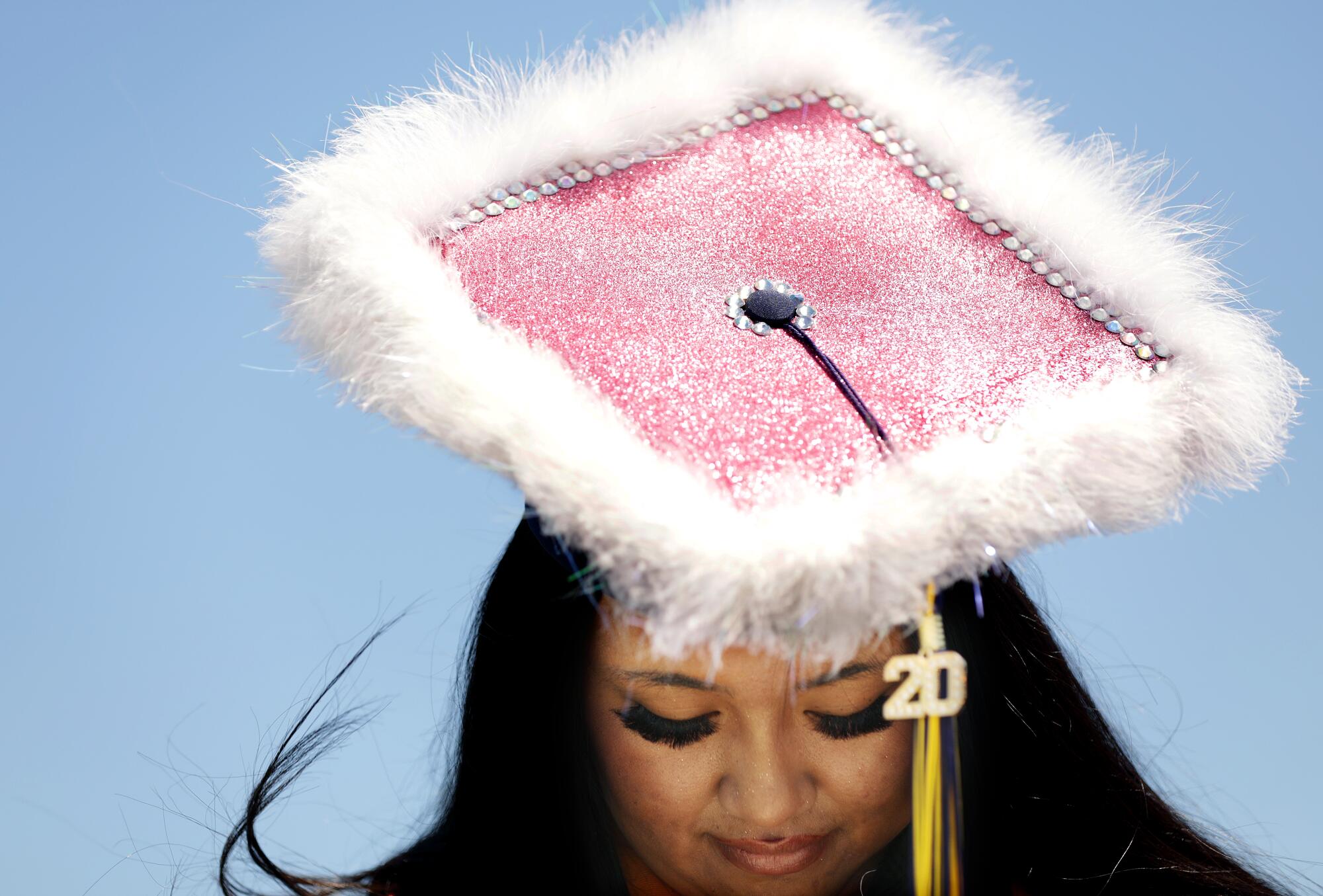 Agnes Cosico shows off her cap at a drive-through graduation ceremony for California High School in Whittier.