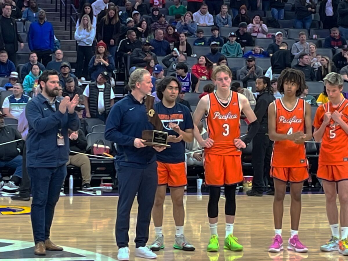 Pacifica Christian Orange County boys' basketball coach Jeff Berokoff, second from left, displays the CIF runner-up trophy.