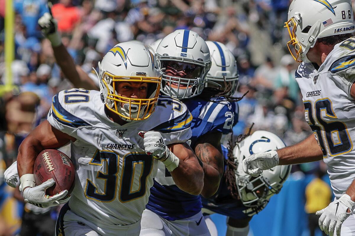The Chargers' Austin Ekeler rushes the football against the Colts.