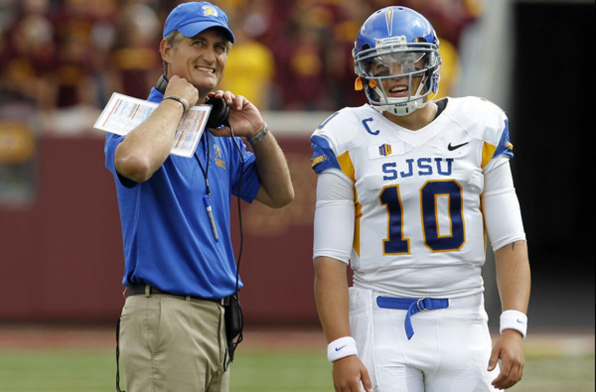 San Jose State Coach Ron Caragher and quarterback David Fales watch as a play is reviewed during the first quarter of their game at Minnesota on Saturday.