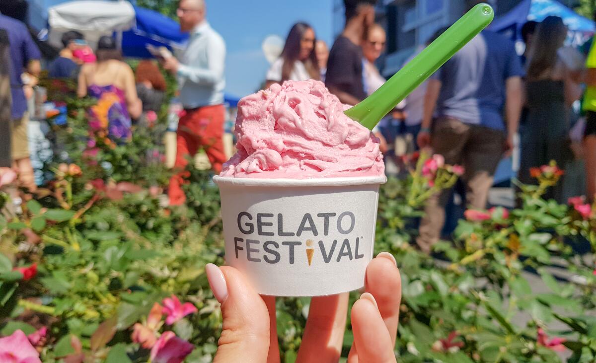 A cup of gelato in front of a festival