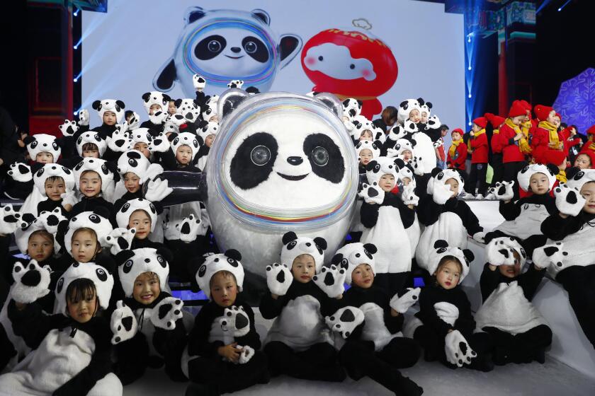 Children dressed as pandas surround a giant panda, mascot of the 2022 Beijing Olympics