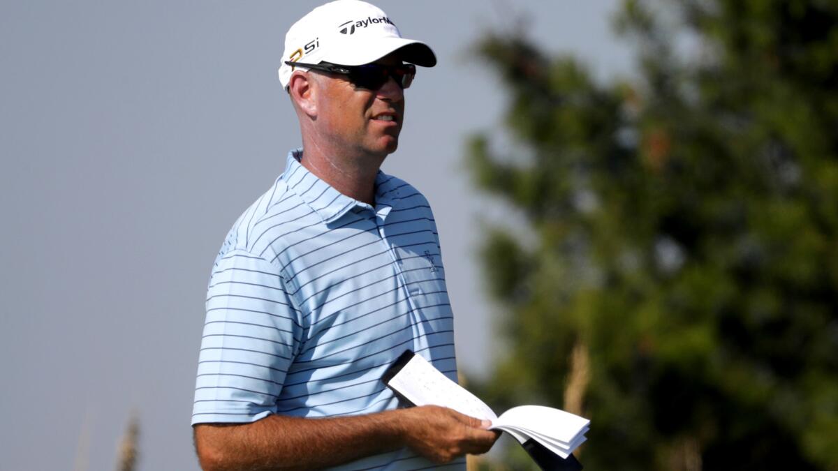 Stewart Cink checks his yardage book before playing a shot during the first round of the RSM Classic on Thursday.