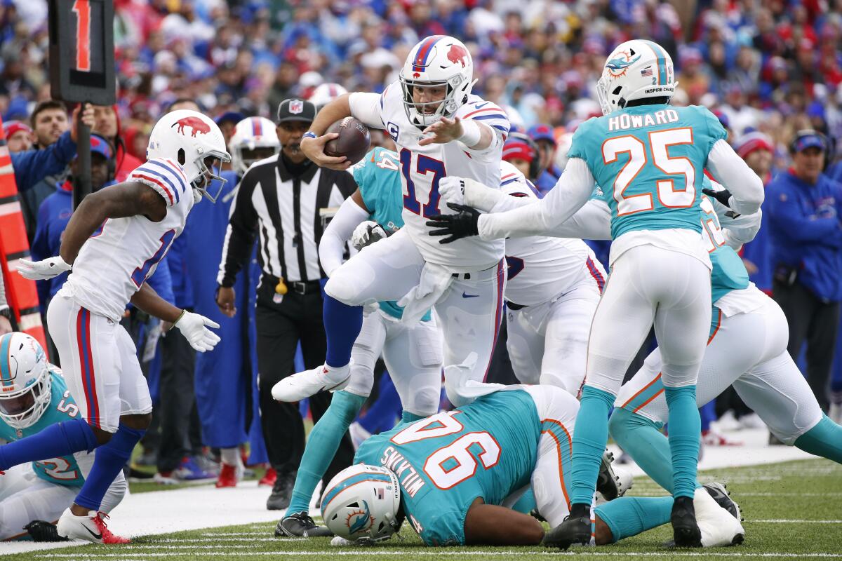 Buffalo Bills quarterback Josh Allen leaps over Miami Dolphins defensive end Christian Wilkins.