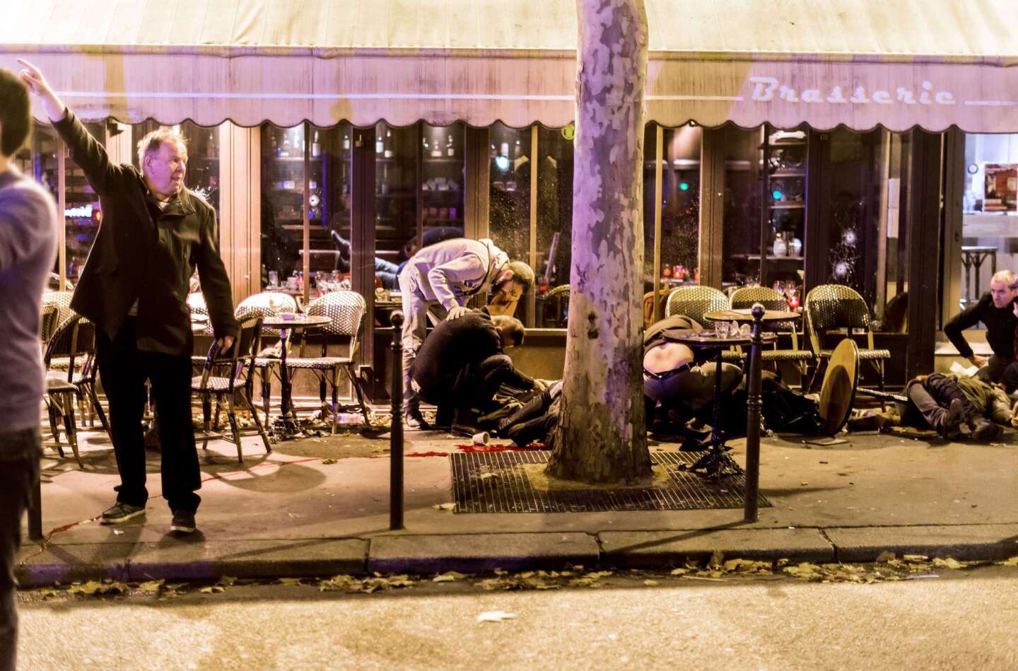 People lie on the pavement near the Cafe Bonne Biere in Paris following a series of attacks.