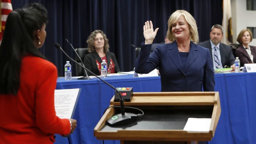 Katrina Foley takes the oath of office Tuesday evening as she is sworn in as Costa Mesa's first directly elected mayor by Orange County Superior Court Judge Karen Robinson, left, a former Costa Mesa mayor.