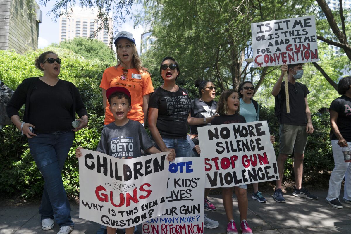 FILE - Protesters chant slogans outside the George R. Brown Convention Center to protest the National Rifle Association annual meeting in Houston, May 27, 2022. March for Our Lives and other gun control groups plan to mobilize supporters on June 11, 2022, to push Congress to require universal background checks, to pass red flag laws allowing guns to be confiscated in certain cases and to raise the age limit to purchase certain guns after recent mass shootings. (AP Photo/Jae C. Hong, File)