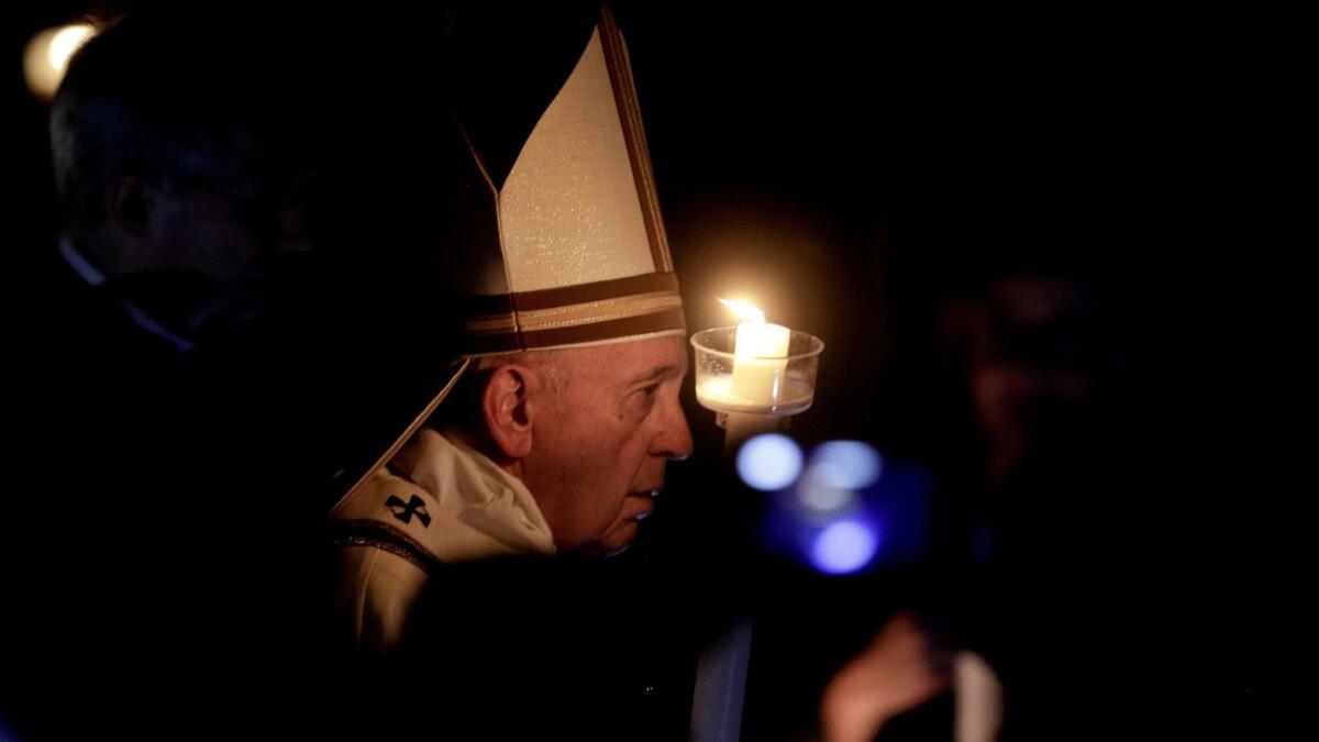 Pope Francis holds a candle as he presides over a solemn Easter vigil ceremony in St. Peter's Basilica at the Vatican on Saturday.
