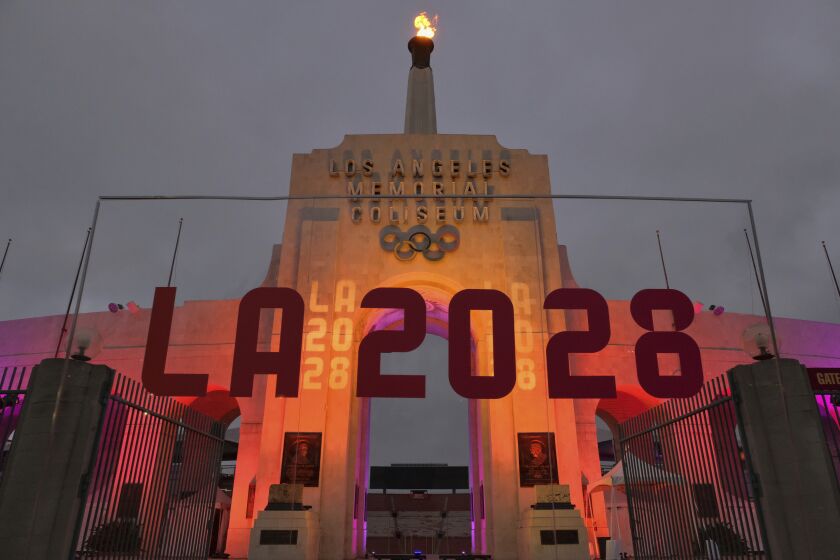 FILE - In this Sept. 13, 2017, file photo, an LA 2028 sign is seen in front of a blazing Olympic cauldron at the Los Angeles Memorial Coliseum. The venue will be renamed United Airlines Memorial Coliseum. University of Southern California President C.L. Max Nikias announced the new name Monday, Jan. 29, 2018, during a ceremonial groundbreaking for a $270 million renovation of the 95-year-old stadium. (AP Photo/Richard Vogel, File)