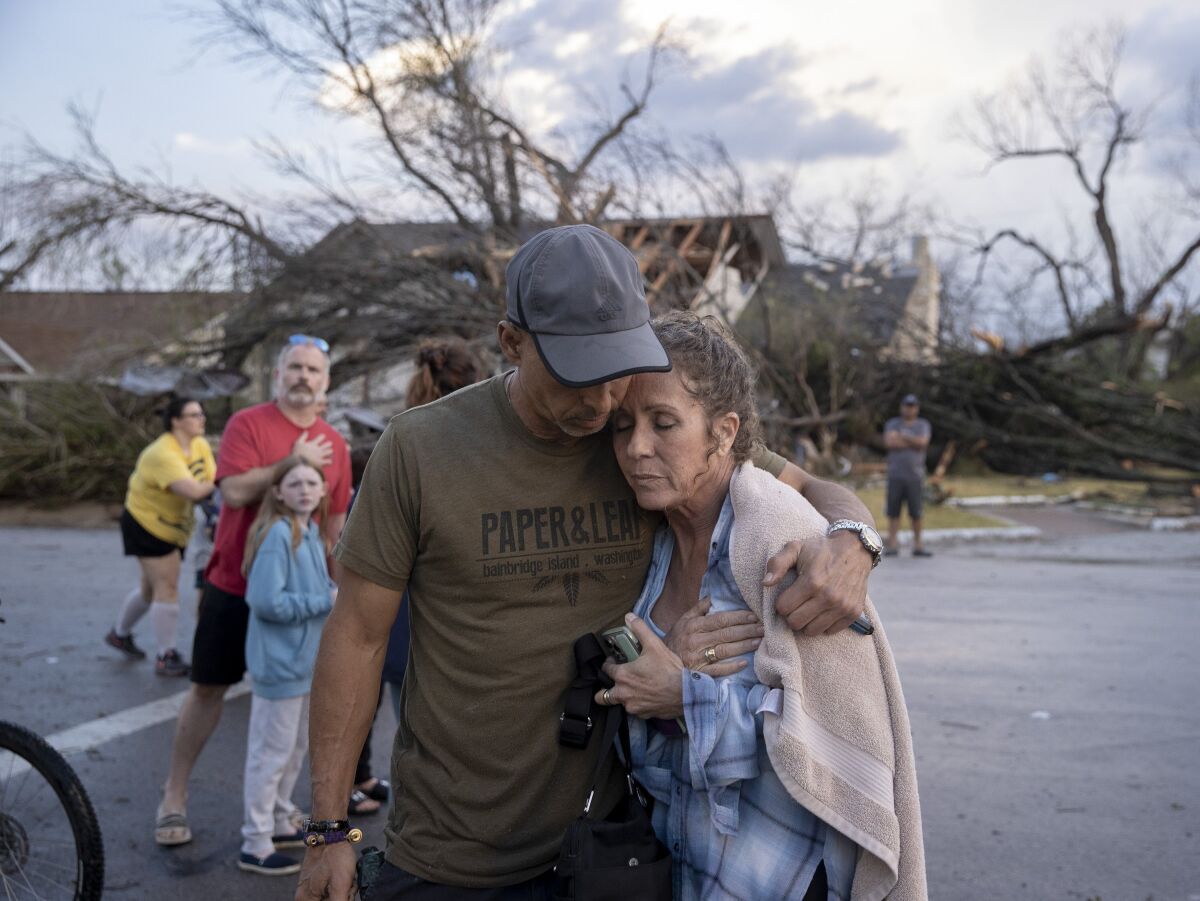 Michael Talamantez comforts his girlfriend Derry Schroer after Talamantez's house was destroyed