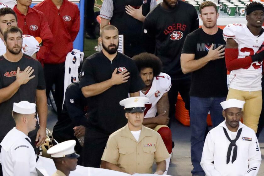Former Green Beret Nate Boyer, second from right, stands next to a kneeling Colin Kaepernick during the national anthem on Thursday.