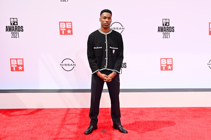 A man in formal attire on a red carpet