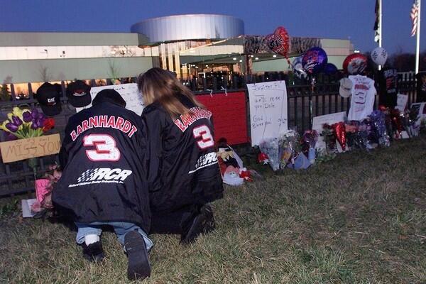 NASCAR fans Ronnie (L) and Vickie Pethel of Concord, NC, say a prayer at a memorial outside driver Dale Earnhardt's corporate headquarters 19 February 2001 in Moorseville, NC. The memorial was started by fans paying tribute to Earnhardt, who was killed during a final lap crash of the 18 February 2001 Daytona 500 NASCAR race.