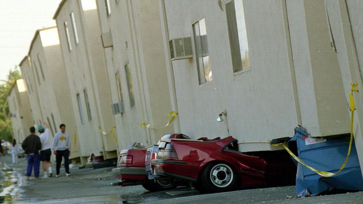 Cars are squashed underneath collapsed apartment buildings in the 19100 block of Victory Boulevard in Tarzana after the 1994 Northridge earthquake. The buildings were declared unihabitable.