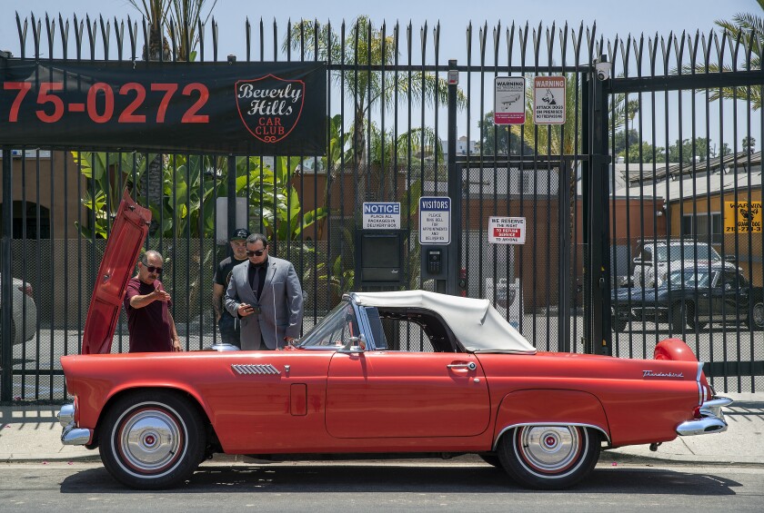 Louie Barrera shows his car, a 1956 Ford Thunderbird, to a buyer for Beverly Hills Car Club.