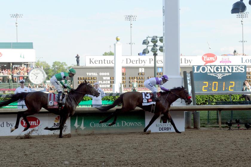 Nyquist, ridden by jockey Mario Gutierrez, holds off Exaggerator down the stretch to win the Kentucky Derby.