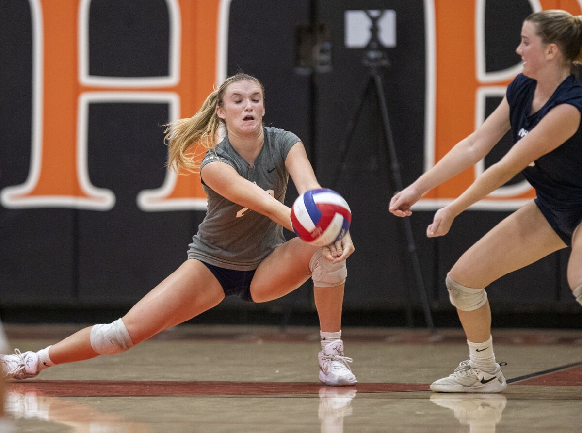 Newport Harbor's Laine Briggs digs a ball during a Surf League girls' volleyball match against Huntington Beach on Thursday.