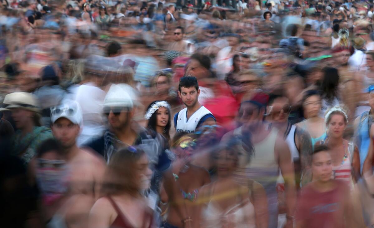 Shara Soo, 27, left, and friend Tyler Kiefer, 23, of San Francisco, stand in a sea of moving people on the first weekend of the 2014 Coachella Music and Arts Festival.