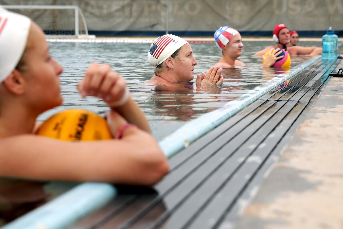Members of the U.S. Women’s water polo team listen to their coach.