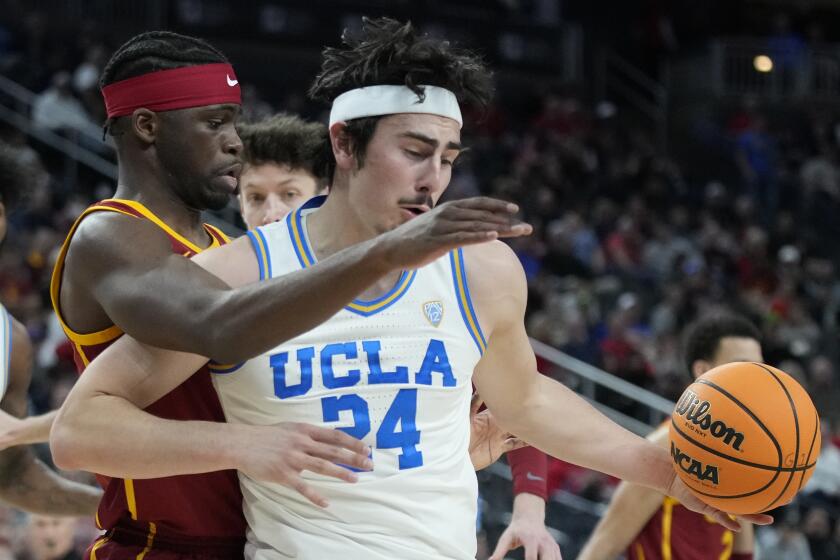 UCLA's Jaime Jaquez Jr., with the ball, battles USC's Chevez Goodwin during the first half March 11, 2022, in Las Vegas.