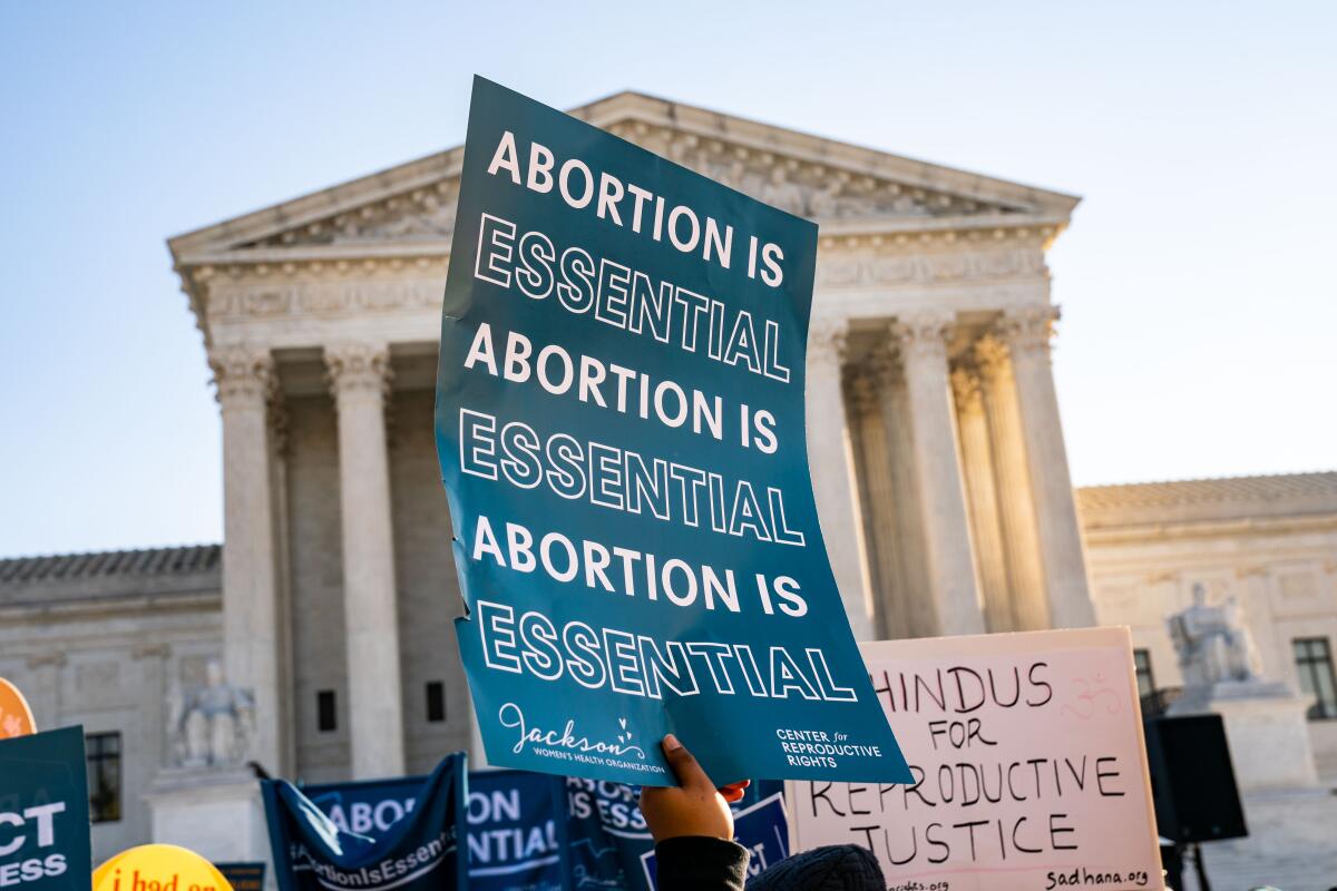 A sign repeating "Abortion is essential" held up in front of the Supreme Court building 