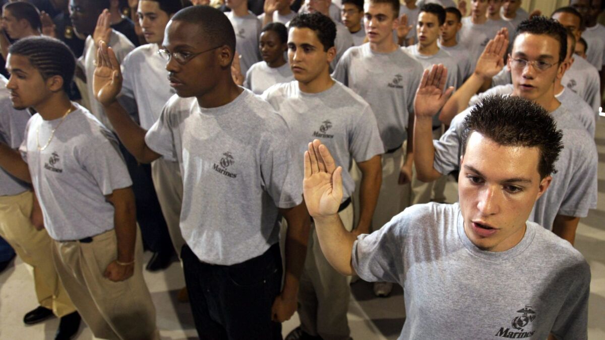 Recruits raise their hands during a joint forces swearing-in ceremony for enlistees April 29, 2004, in Fort Lauderdale, Florida.