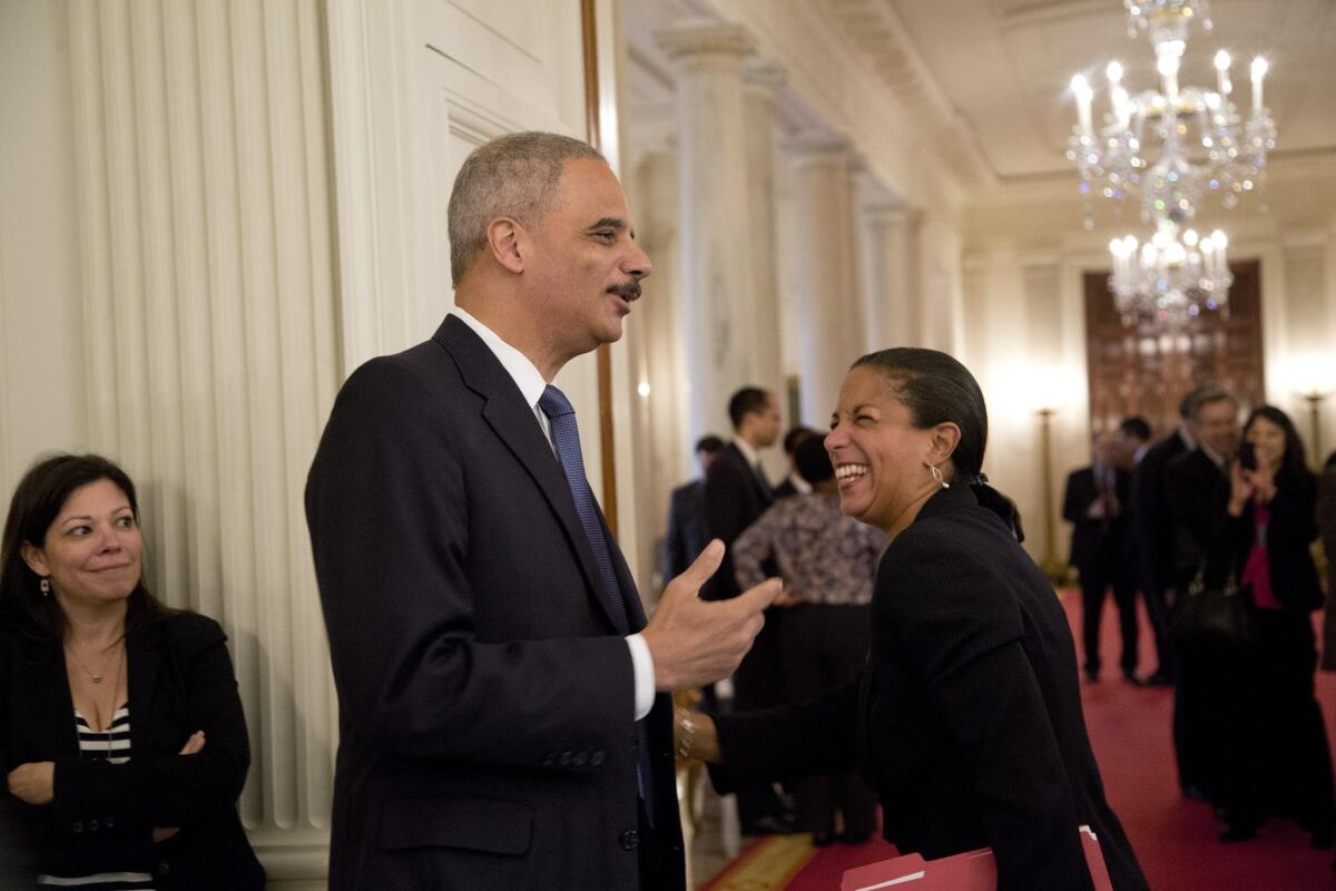 U.S. Atty. Gen. Eric Holder laughs with National Security Advisor Susan Rice in the State Dining Room of the White House in Washington on Thursday, after President Obama announced Holder's resignation.