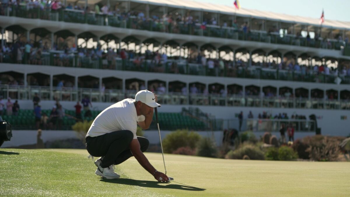 Professional golfer Brooks Koepka crouches to the grass.