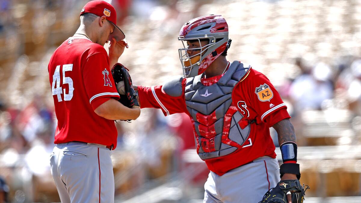Angels starting pitcher Tyler Skaggs gets a visit from catcher Martin Maldonado during the first inning. Skaggs recorded only two outs while giving up four walks and three runs.