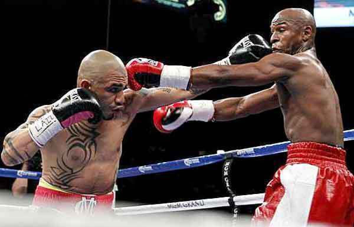 Miguel Cotto, left, and Floyd Mayweather Jr. trade punches during their bout Saturday night in Las Vegas.