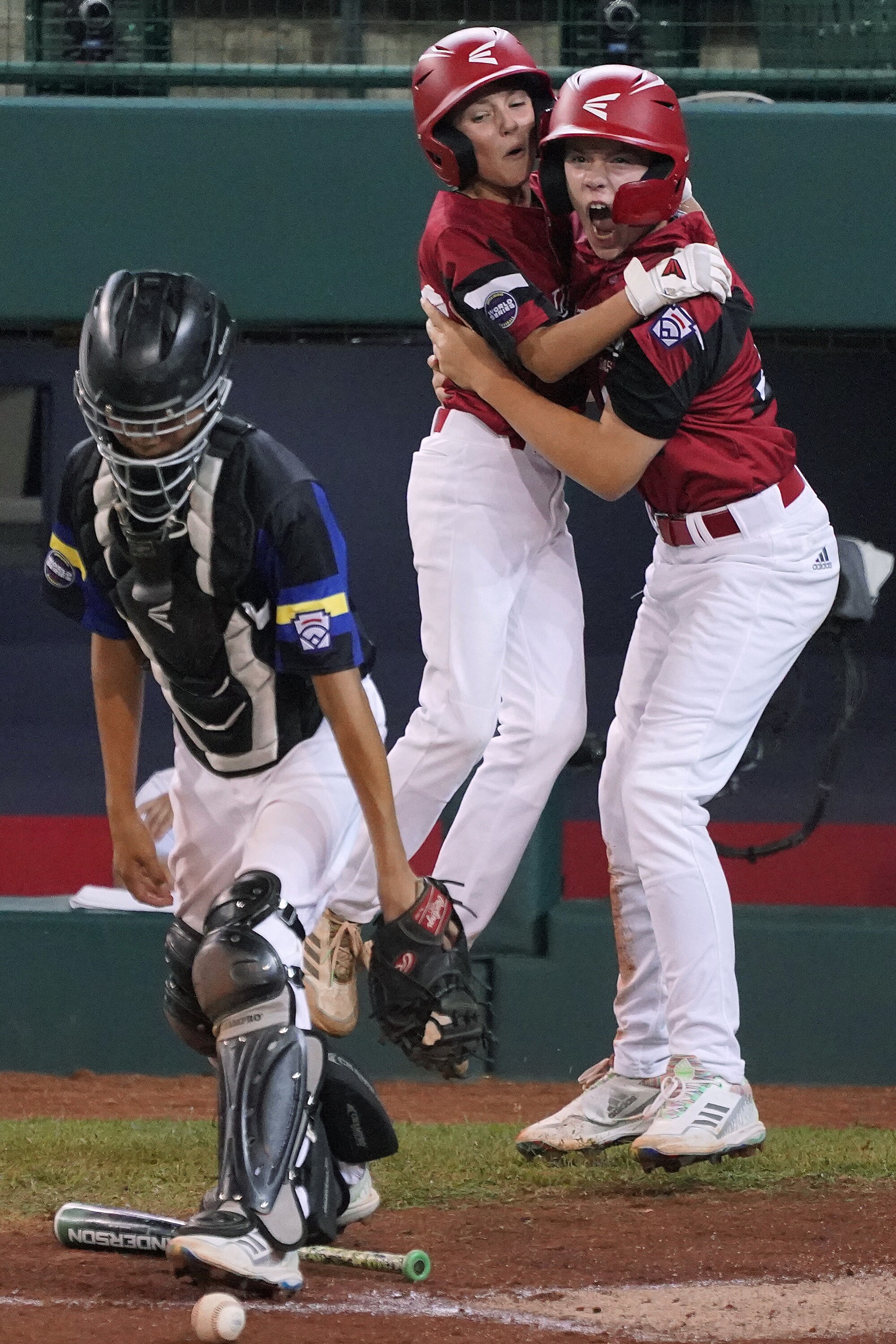 Hamilton, Ohio's JJ Vogel, right, and Brady Baumann celebrate near Torrance, Calif., catcher Brandon Perez.