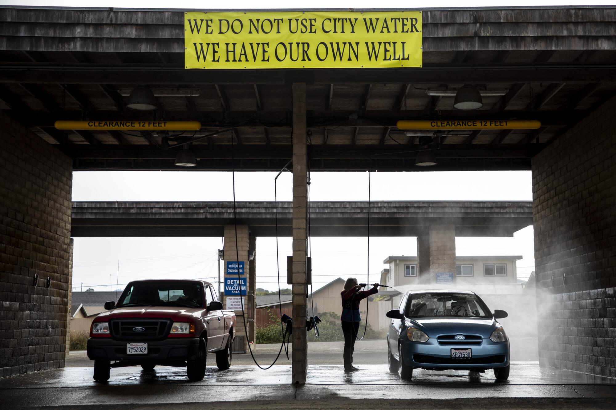 A bright yellow sign above a car wash reads "We Do Not Use City Water, We Have Our Own Well."
