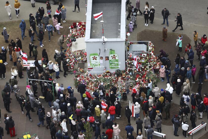 People gather to honor 31-year-old Raman Bandarenka, who died Thursday at a Minsk hospital after several hours of surgery due to serious injuries in Minsk, Belarus, Friday, Nov. 13, 2020. Thousands of people have rallied in Belarus on Friday following the death of a 31-year-old opposition supporter who died in a hospital after he was reportedly beaten by security forces, and the European Union condemned the continued violent crackdown that Belarusian authorities have waged on peaceful protesters. (AP Photo)