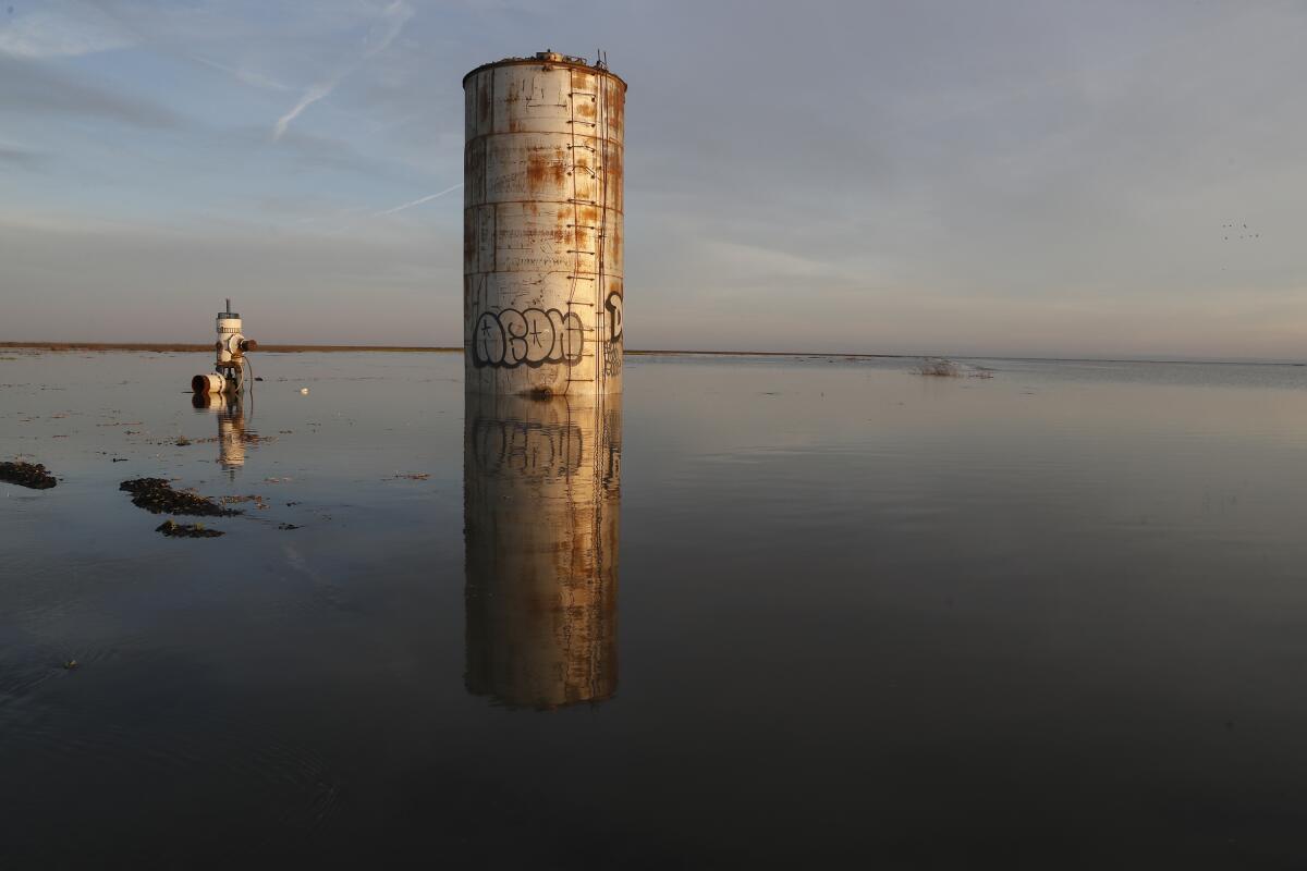 A silo surrounded by water.