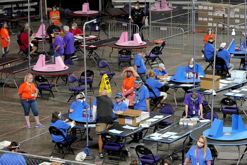 ARCHIVO - Votos en el condado de Maricopa en la elección general de 2020 son revisados y recontados por funcionarios electorales en una empresa basada en Florida, en el Cyber Ninjas en el Memorial Coliseum por los Veteranos en Phoenix, el 6 de mayo de 2021. (AP Foto/Matt York, Pool, Archivo)