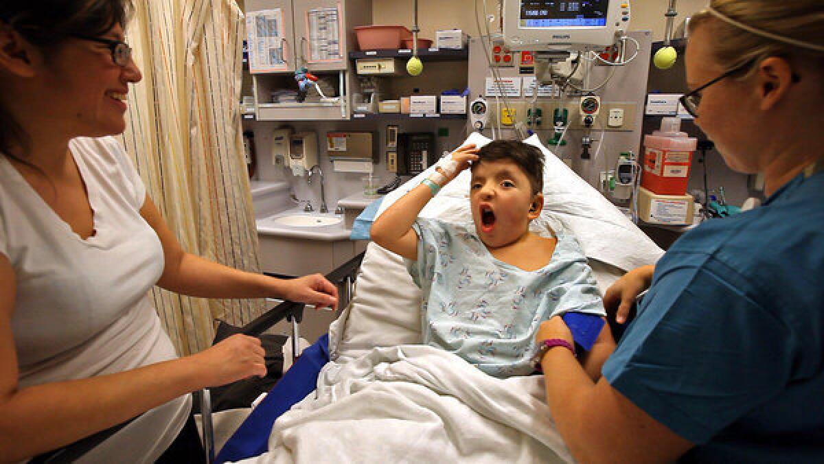 After his surgery, James Weatherwax expresses surprise at finding the halo gone as his mother, Kecia, left, looks on at the hospital in Seattle.