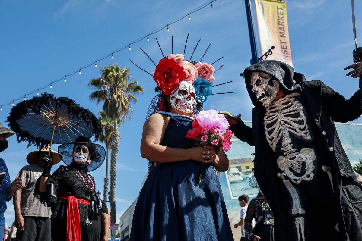 Several people dress in traditional Day of Dead masks and face paints in the Oceanside Dia de los Muertos Festival 
