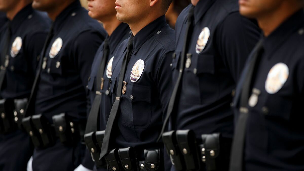 New LAPD officers are sworn in at a graduation ceremony last summer. Voters will decide Tuesday whether to allow officers accused of serious misconduct to have their cases heard by an all-civilian disciplinary panel.