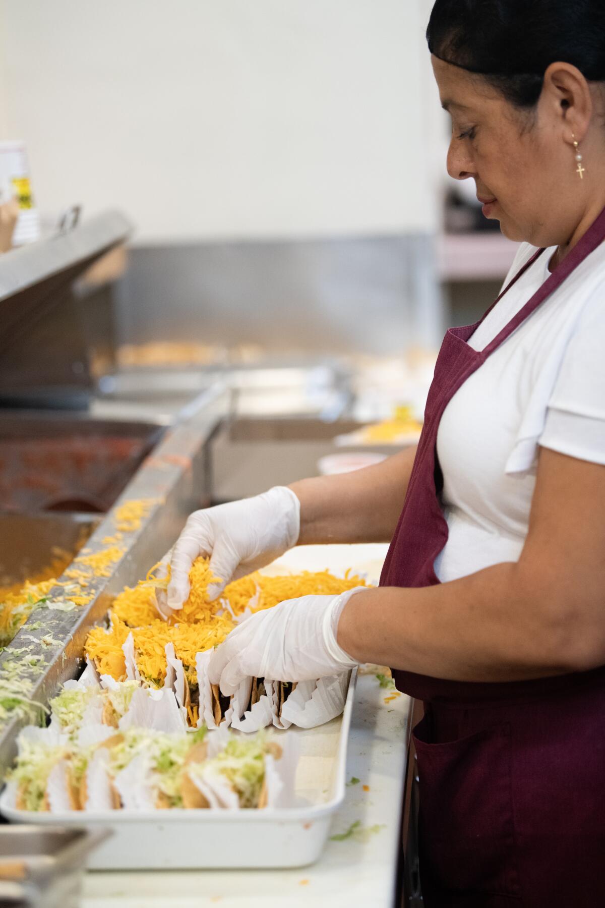 Inside the kitchen at Tito's Tacos, employees prepare large quantities of tacos in an effort to keep up with customer demand and ensure the food line moves quickly and smoothly.
