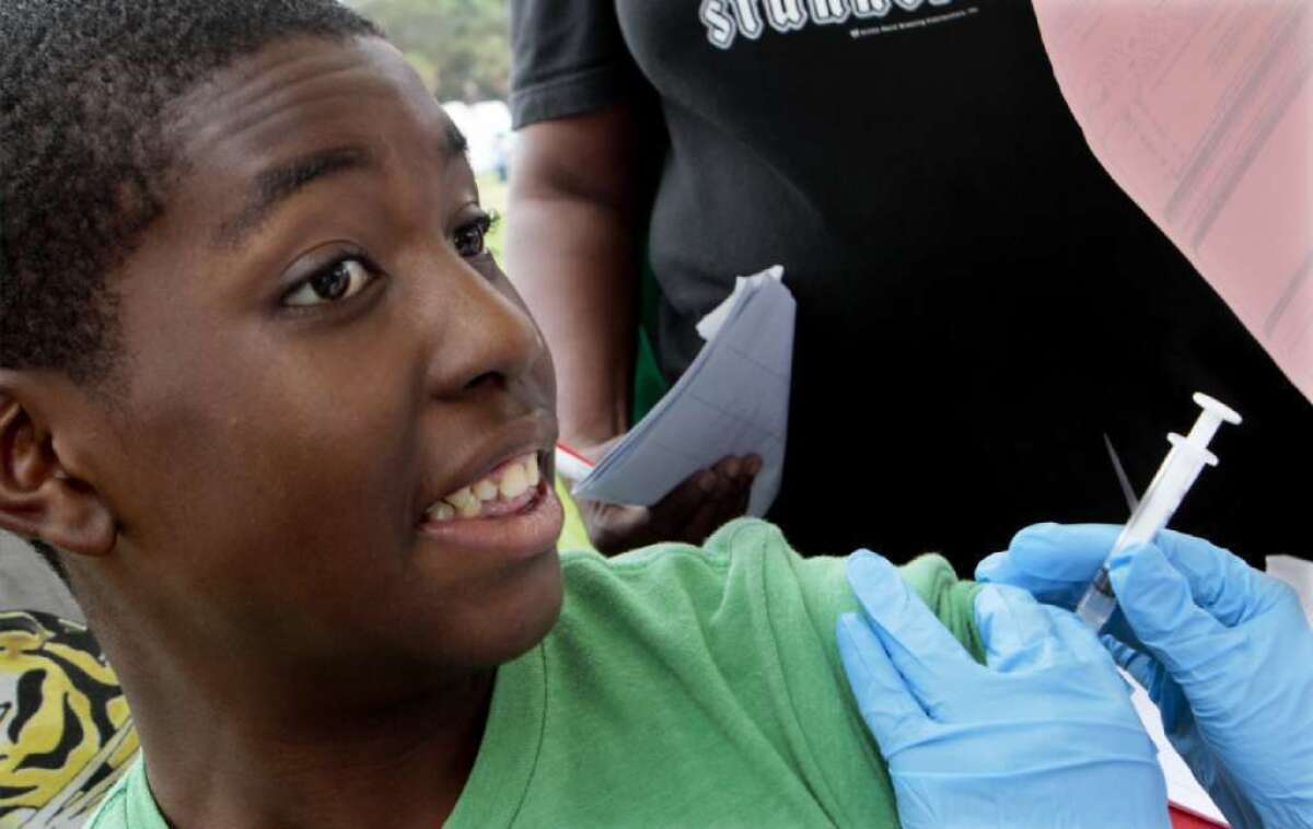Tyree Harper, 12, receives the whooping cough vaccine in 2012 at Jesse Owens Park in Los Angeles. Cases of whooping cough have risen in Long Beach, health officials say.